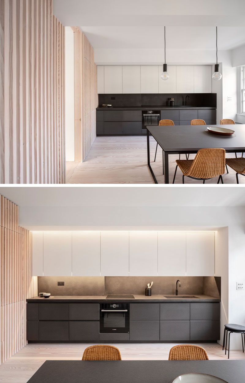 Interior Design Ideas - The wood slat wall in this modern apartment incorporates secret doors, and all storage and service requirements for the apartment, including kitchen appliances and hanging cupboards, resulting in a highly efficient plan. #InteriorDesignIdeas #WoodSlatWall #HiddenAppliances #HiddenFridge #IntegratedFridge #HiddenStorage #SecretDoors #HiddenDoors