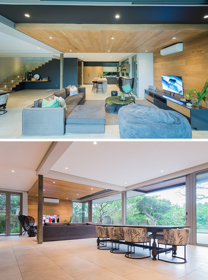 LIVING ROOM IDEAS - One of the most eye-catching design elements of this modern interior by Metropole Architects, was the inclusion of a wrap-around wood accent wall in the living room that travels from the wall up onto the ceiling. #LivingRoom #WoodAccentWall #WoodCeiling #InteriorDesign #AccentWall #LivingRoomIdeas