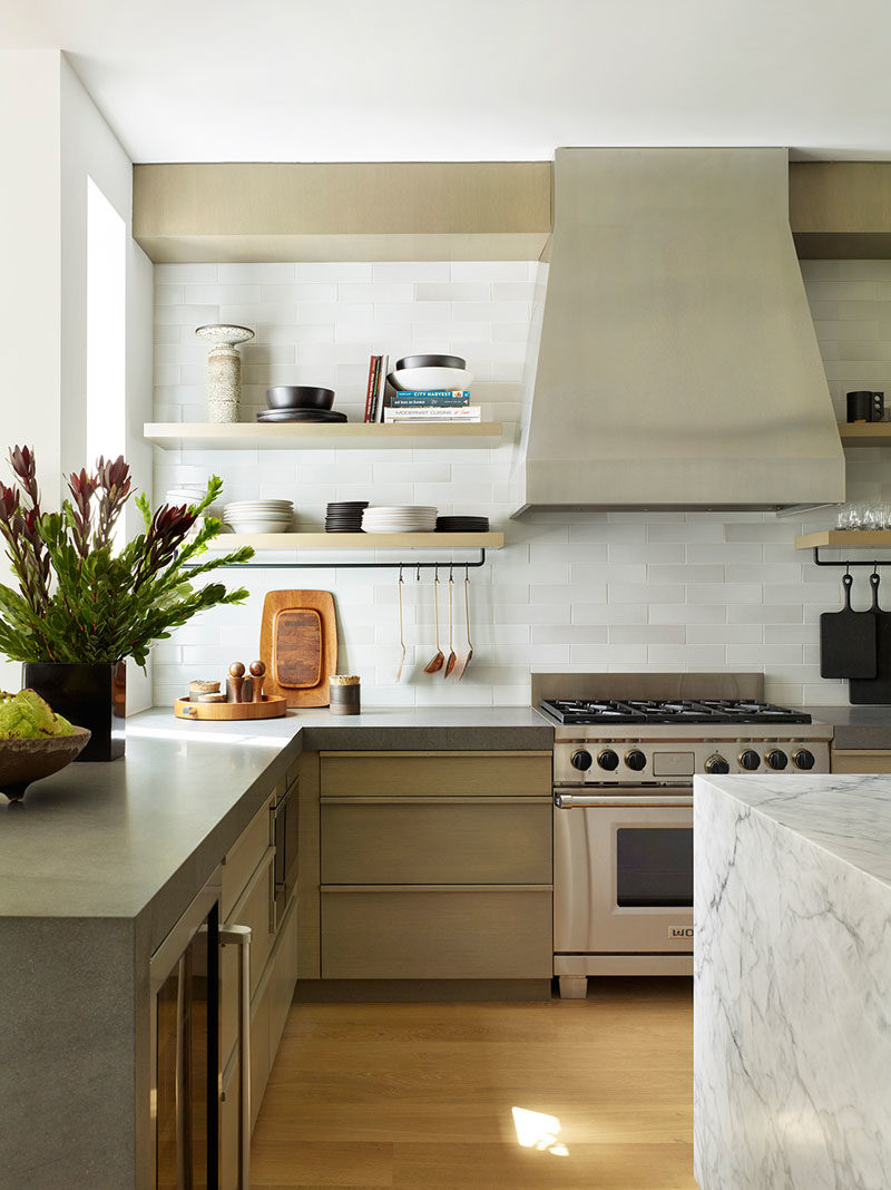 Kitchen Ideas - In this contemporary kitchen, thick honed basalt has been used for the back counters, and handmade tiles from Heath Ceramics are showcased on the backsplash. Above the stone island is a custom architectural chandelier from the Thomas Hayes Gallery. #KitchenDesign #KitchenIdeas