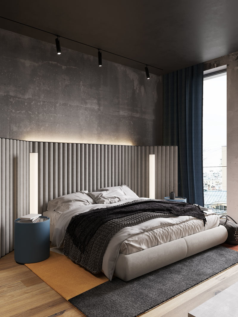 Bedroom Ideas - In this modern bedroom, the concrete walls were left bare, while hidden lighting behind the headboard adds a soft glow to the room. #BedroomIdeas #ModernBedroom #BacklitHeadboard