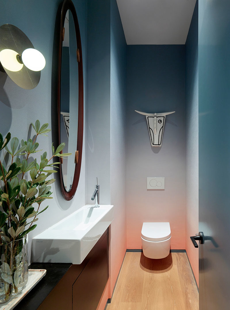 Bathroom Ideas - This modern powder room features an ombre wallpaper and an ox mask by Norwegian artist Arne Lindaas. #PowderRoom #BathroomIdeas #BathroomDesign