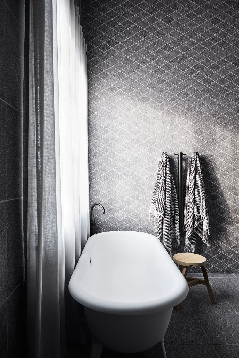 Bathroom Ideas - This modern master bedroom ensuite has a feature wall of custom-cut terrazzo diamond tiles that provides a backdrop for an Agape bathtub.