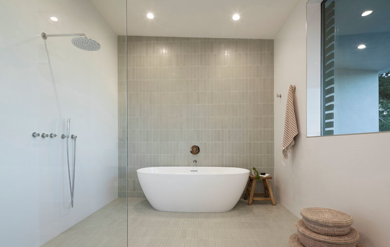 Bathroom Ideas - In this modern bathroom, a wall of vertical tiles acts as a backdrop for the freestanding bathtub. #BathroomIdeas #ModernBathroom