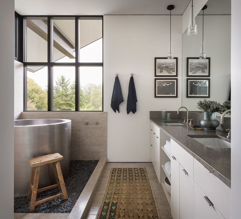 Bathroom Ideas - In thsi modern master bathroom, a deep soaking tub is positioned to take advantage of the treetop views. #BathroomIdeas #ModernBathroom #SoakingTub