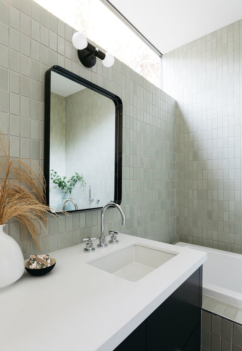 Bathroom Ideas - This modern bathroom features clerestory windows that provide a glimpse of the trees, while a bathtub has been built-in beside the vanity. #BathroomIdeas #ModernBathroom #BathroomDesign