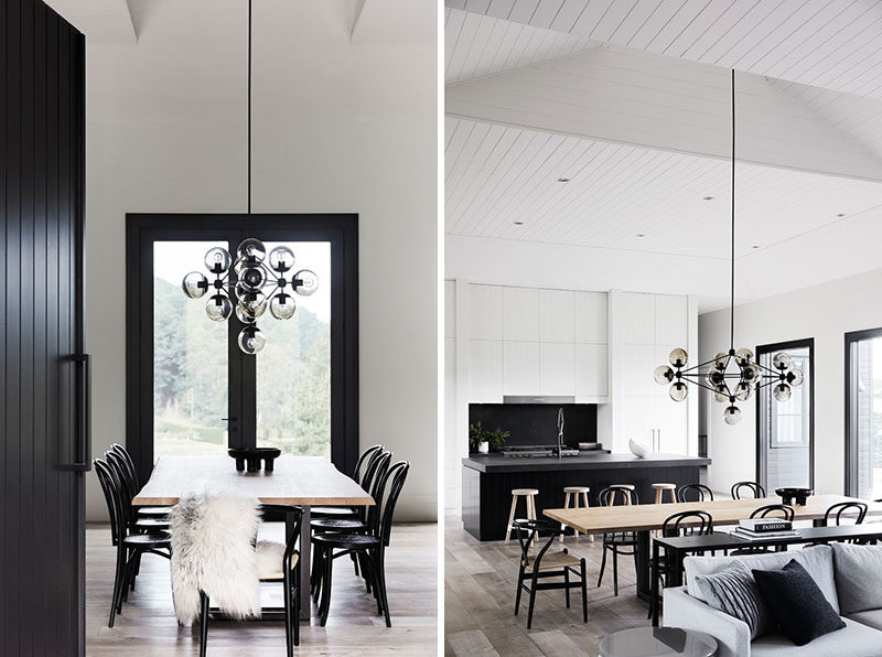 Dining Room Ideas - Stepping inside this modern farmhouse, the double-height ceilings in the open plan interior contribute to the sense of spaciousness, while floor-to-ceiling glass doors and windows offer a strong connection to the outdoors, and frame views of the surrounding farmland. #DiningRoom #DiningRoomIdeas #ModernFarmhouse