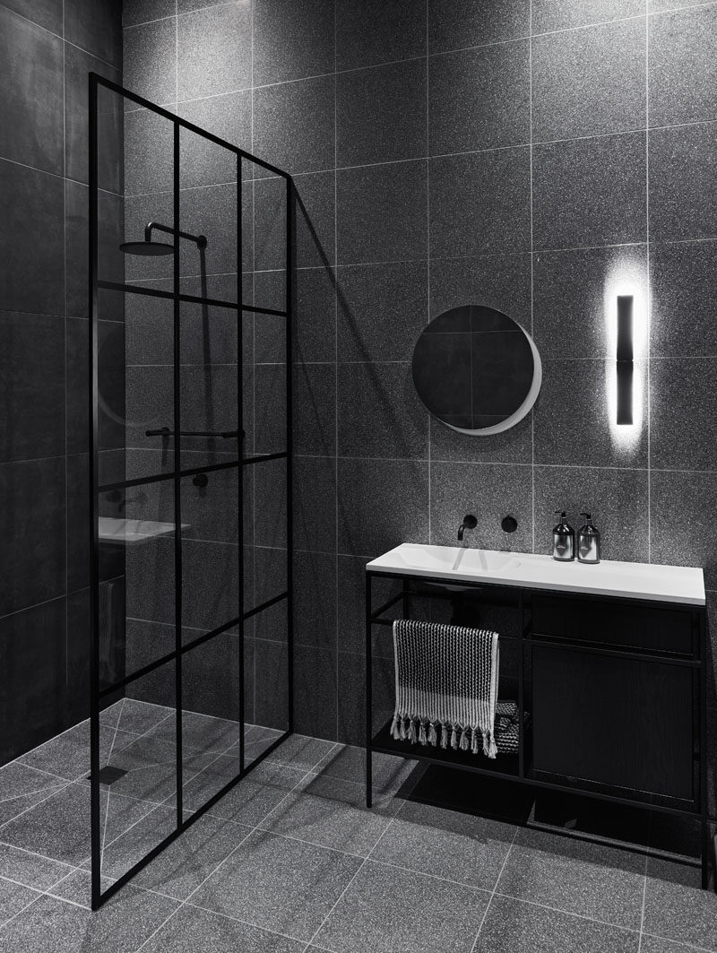 Bathroom Ideas - In this modern black and grey bathroom, a black-frame grid shower screen is inspired by the existing window frames of the house. #BathroomIdeas #BlackBathroom #BathroomDesign