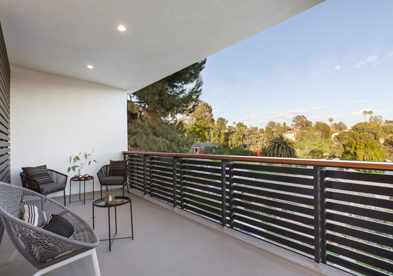 This modern covered balcony has a steel and wood handrail, while built-in lights allow the balcony to be used at night #BalconyDesign