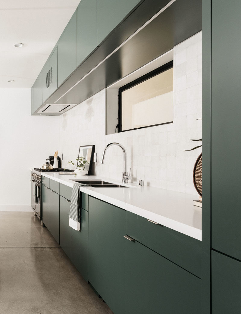 Kitchen Ideas - this modern kitchen features minimalist deep green cabinets paired with a light backsplash and countertop. #ModernKitchen #GreenKitchen #KitchenIdeas