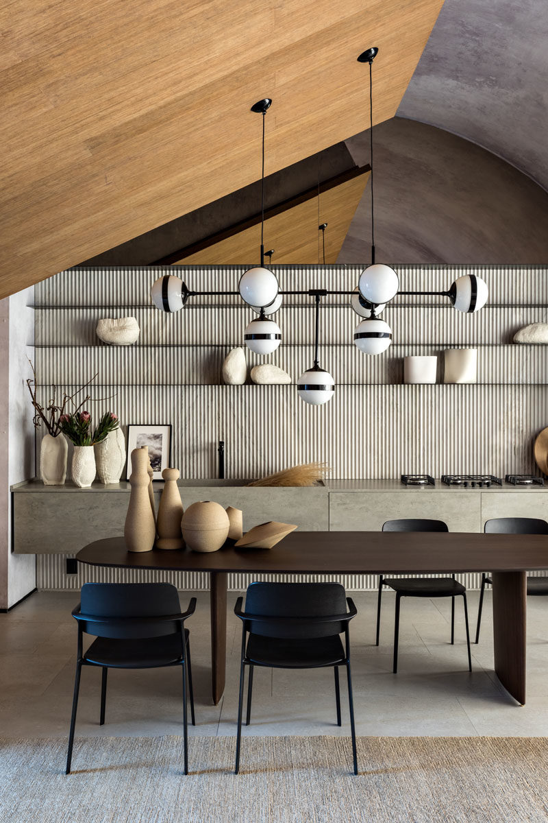 Dining Room Ideas - A large wood dining table from MisuraEmme is positioned below a large chandelier by the Italian Hangar Design Group. #DiningRoom #DiningRoomIdeas