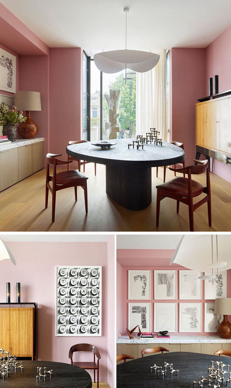 Dining Room Ideas - In this modern dining room, soft pink has been used to create a colorful backdrop for the artwork and dining table, which was designed by Jamie Bush + Co., and is shaped like an oblong pebble with a highly textured wire-brushed finish, that exposes the grain of the blackened oak. #DiningRoomIdeas #DiningRoom #PinkRoom #PinkWalls #InteriorDesign