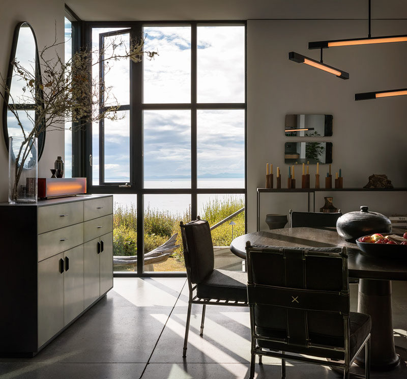 Dining Room Ideas - In the dining room, a Wintercheck Factory Light sits atop a credenza by Wüd Furniture. Iron and saddle leather Casamidy chairs surround the Nolan Dining Table by Troscan Design, while the lighting fixture is Mary Wallis’s Melbourne 3-Tier Pendant in matte black. #DiningRoom #DiningRoomIdeas