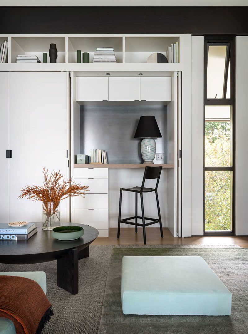 Living Room Ideas - This small living room has a custom-designed shelving unit with a desk hidden within a closet. #HiddenDesk #DeskInCloset #LivingRoomIdeas