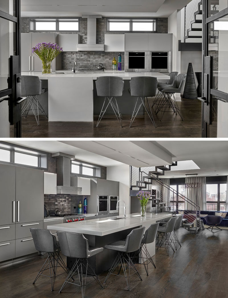 Kitchen Ideas - In this modern kitchen, a double sided 13 foot long, concrete and quartzite island with center waterfall features two eating areas, while the kitchen backsplash showcases exposed brick that's been glazed with gunmetal metallic paint. #KitchenIdeas #ModernKitchen #KitchenIsland #KitchenDesign