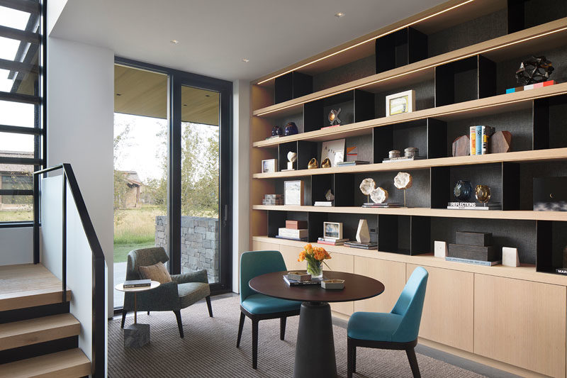 This modern house has a small home office and library area at the bottom of the stairs. #HomeOffice #HomeLibrary #Shelving