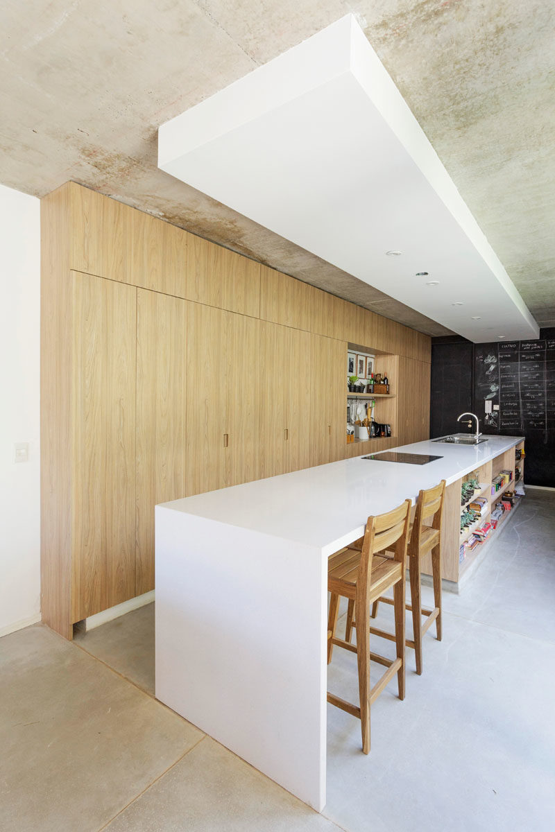 Kitchen Ideas - In this modern kitchen, floor-to-ceiling light wood cabinets have been combined with a long white island for a minimalist look. #ModernKitchen #KitchenIdeas #KitchenDesign