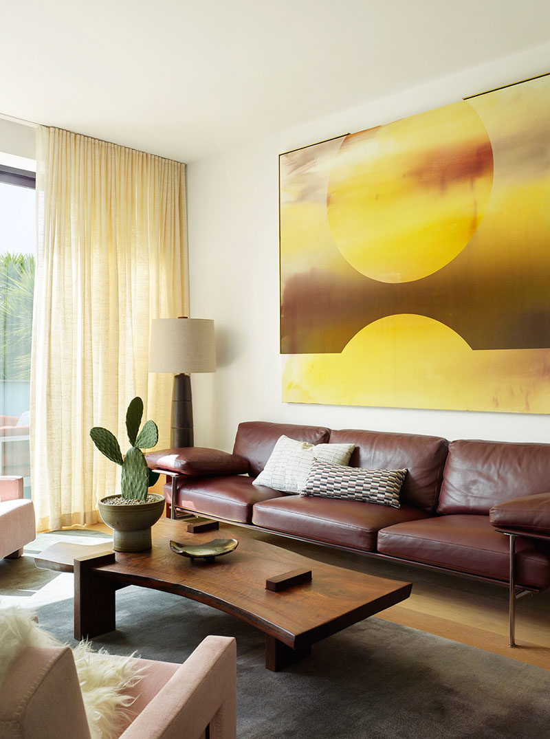 Living Room Ideas - In this modern living room, a custom walnut coffee table by Richard Patterson has been combined with comfortable furnishings and a shelving unit. A sliding door opens up to a small outdoor space. #LivingRoom #LivingRoomIdeas