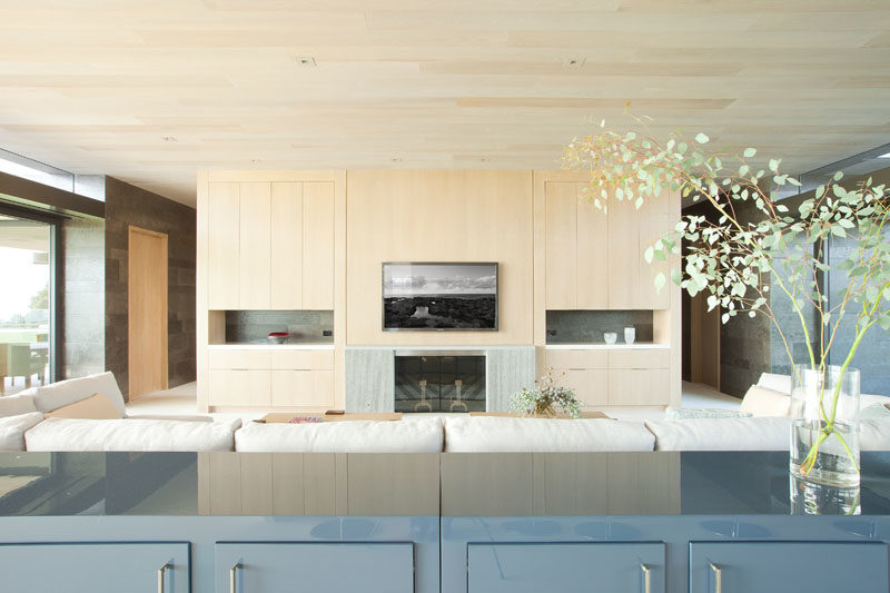 Living Room Ideas - In this modern living room, maple cabinetry clads the entertainment wall, while the ceiling showcases exterior maple siding. #LivingRoomIdeas #ModernLivingRoom