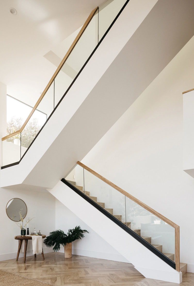 Stair Ideas - This modern house has a large staircase with glass and wood handrails. #Stairs #StairIdeas #ModernStairs #LivingRoomIdeas