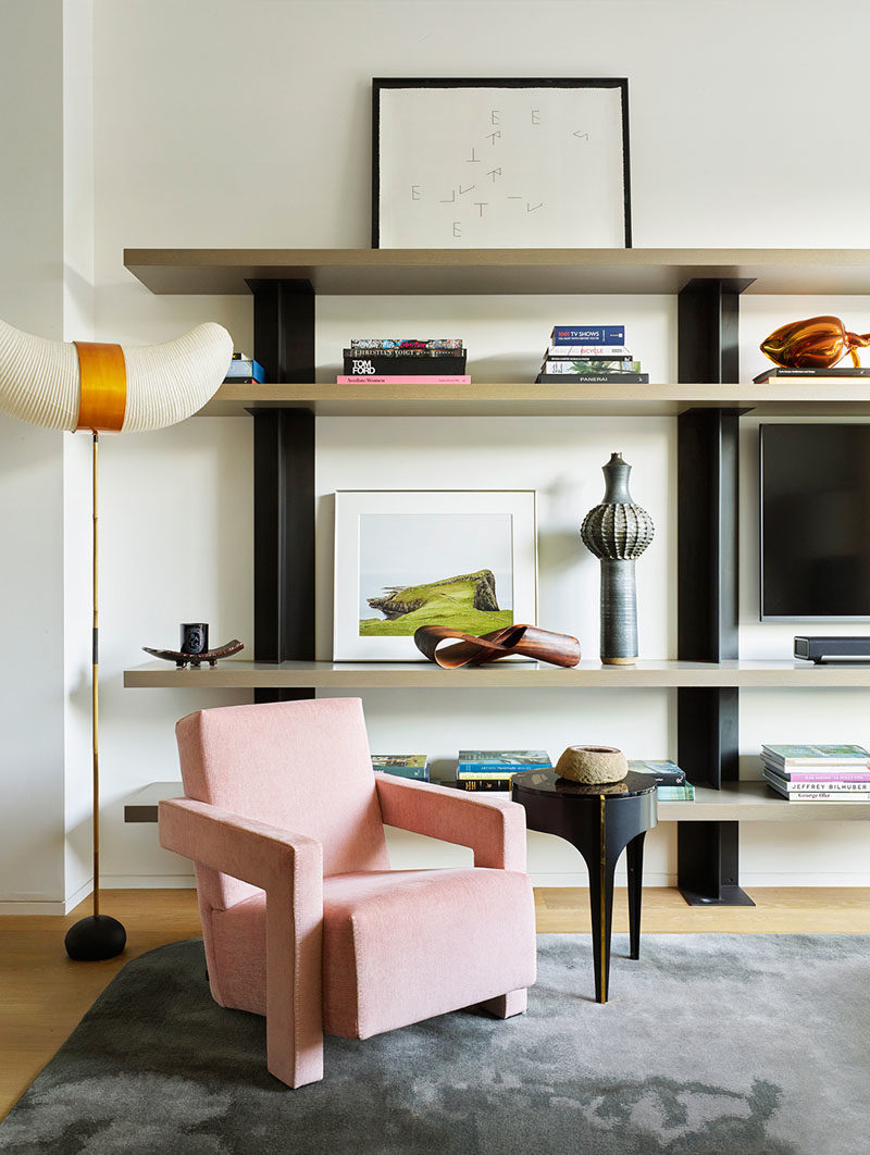 Shelving Ideas - This modern living room has a large shelving unit to display decorative items and artwork. #Shelving #LivingRoom