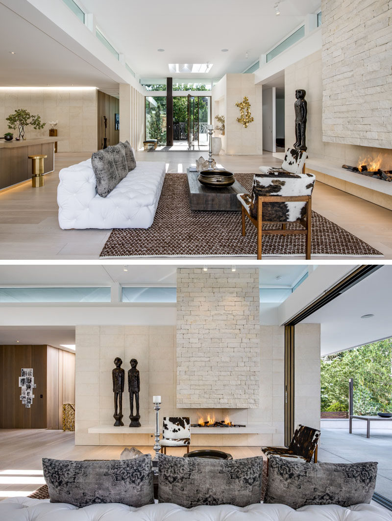 Living Room Ideas - The front entryway of this modern house opens up to the living room that showcases limestone walls and an open flame fireplace. #LivingRoom #Fireplace #LimestoneWalls