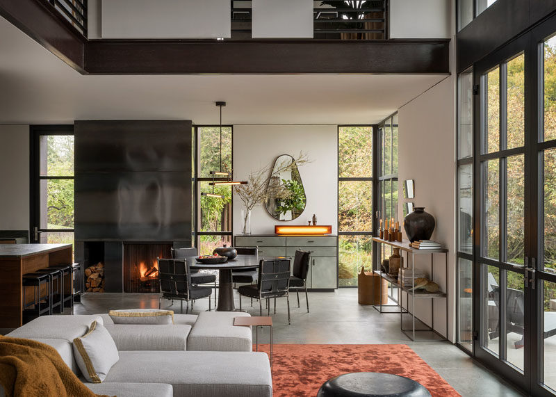 Dining Room Ideas - In the dining room, a Wintercheck Factory Light sits atop a credenza by Wüd Furniture. Iron and saddle leather Casamidy chairs surround the Nolan Dining Table by Troscan Design, while the lighting fixture is Mary Wallis’s Melbourne 3-Tier Pendant in matte black. #DiningRoom #DiningRoomIdeas