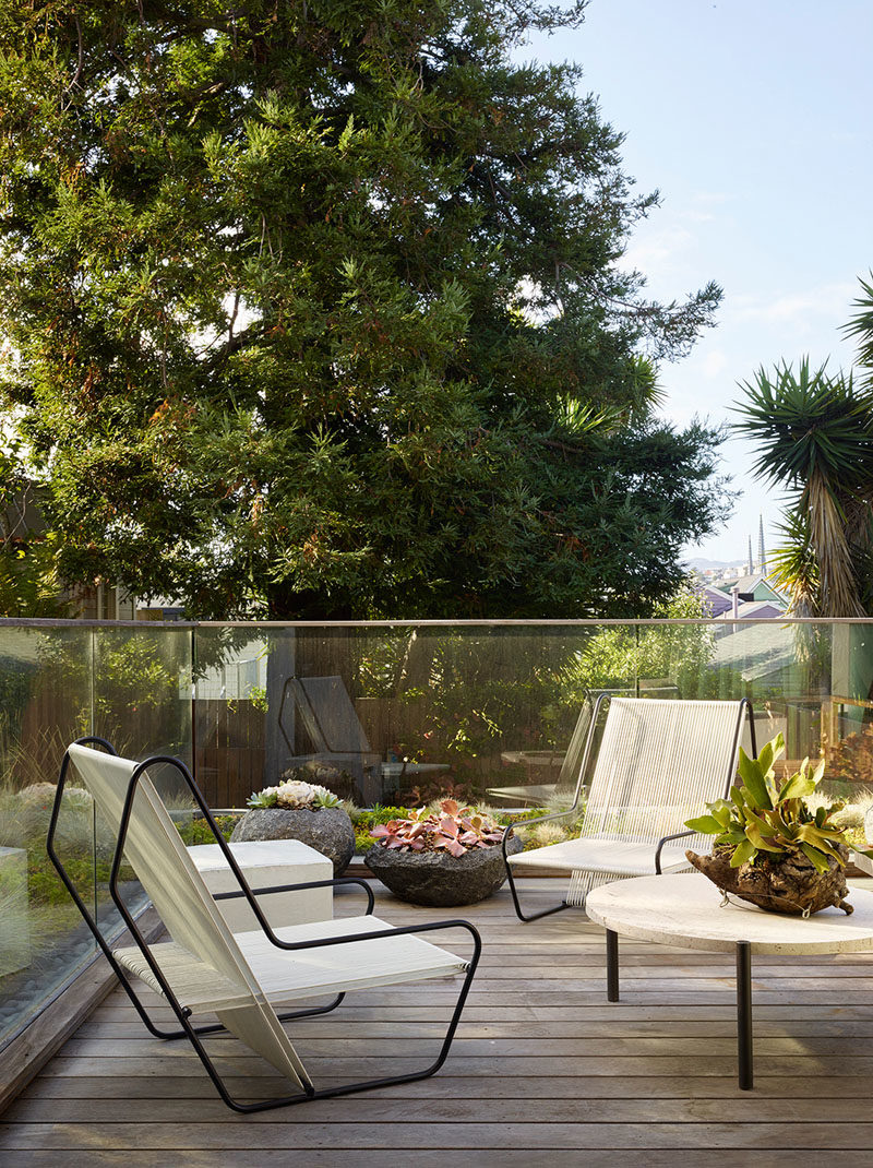 This modern outdoor space furnished with a couple of chairs and tables. Glass handrails provide safety and uninterrupted views. #OutdoorSpace