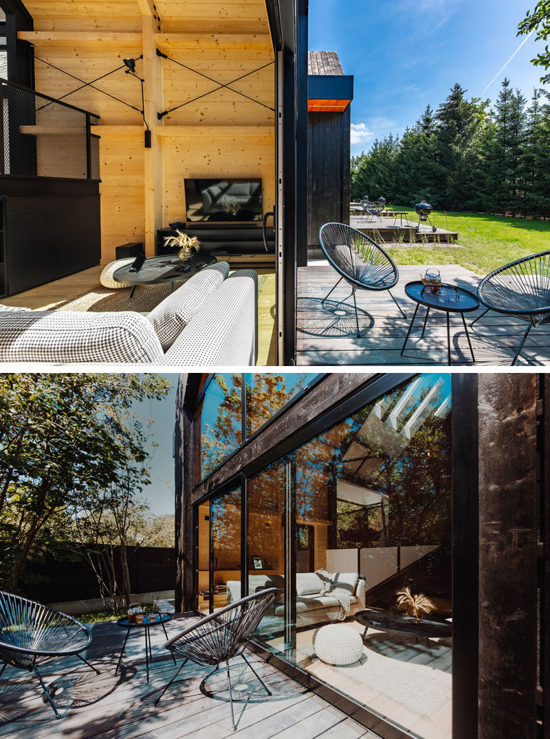 A large sliding glass door opens this modern living room to the rear deck. #Deck #Patio