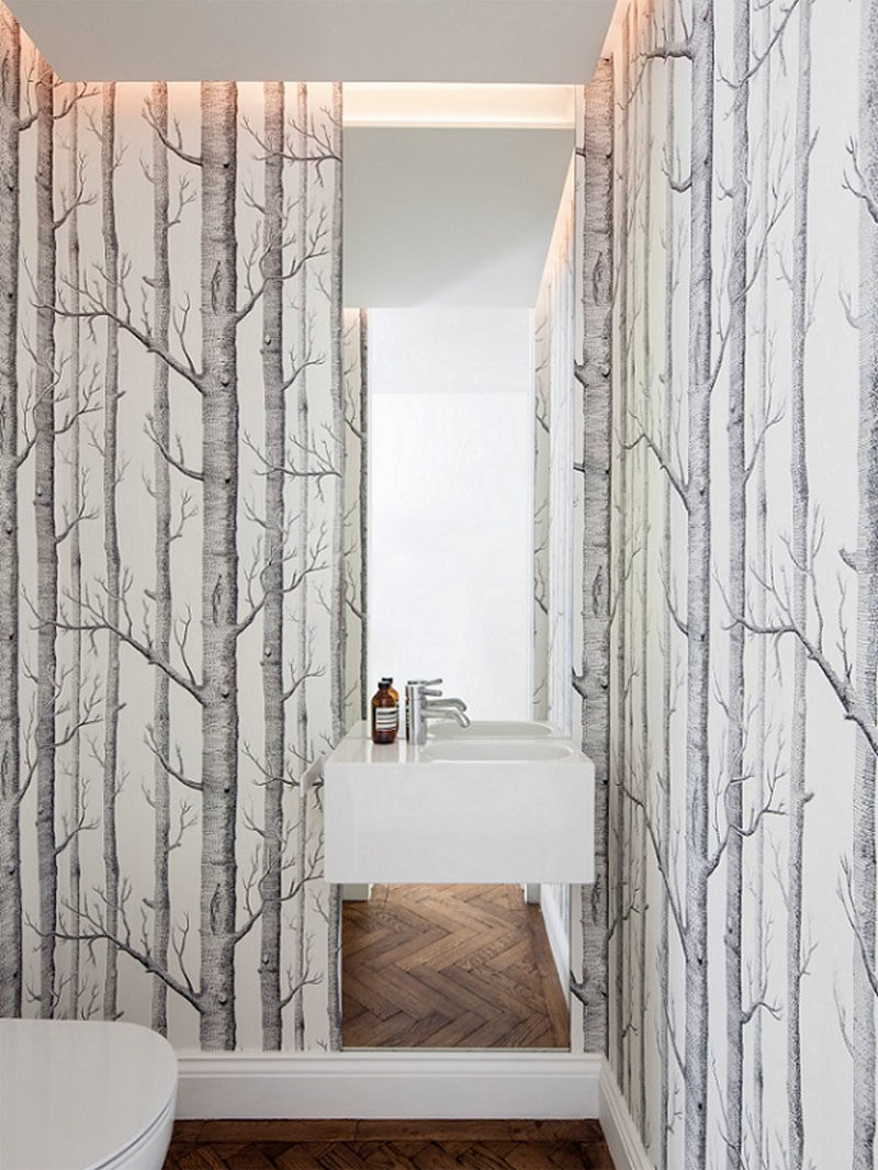 Bathroom Ideas - In this modern powder room, nature has been brought inside with the use of wallpaper with trees. #Bathroom #PowderRoomIdeas #Wallpaper