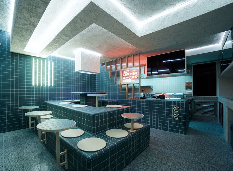 Restaurant Ideas - Deep blue-green tiles and tiered seating have been used throughout this modern restaurant to create a unified appearance that's inspired by retro 60's style and Korean bath houses. #Tile #RestaurantDesign #RestauarantIdeas