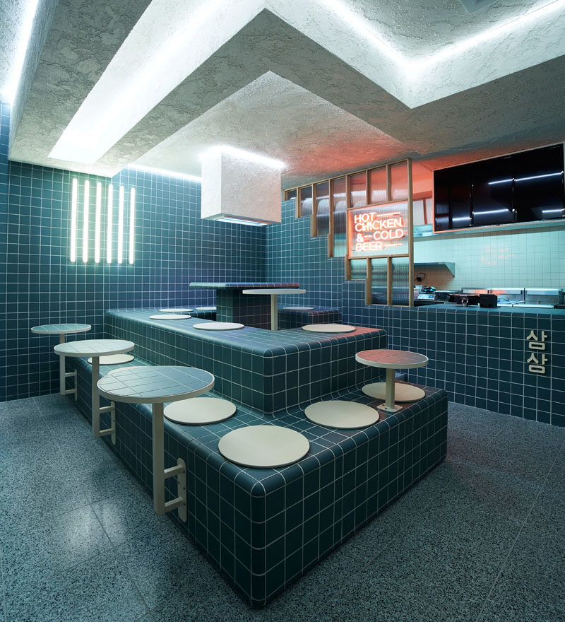 Restaurant Ideas - Deep blue-green tiles and tiered seating have been used throughout this modern restaurant to create a unified appearance that's inspired by retro 60's style and Korean bath houses. #Tile #RestaurantDesign #RestauarantIdeas
