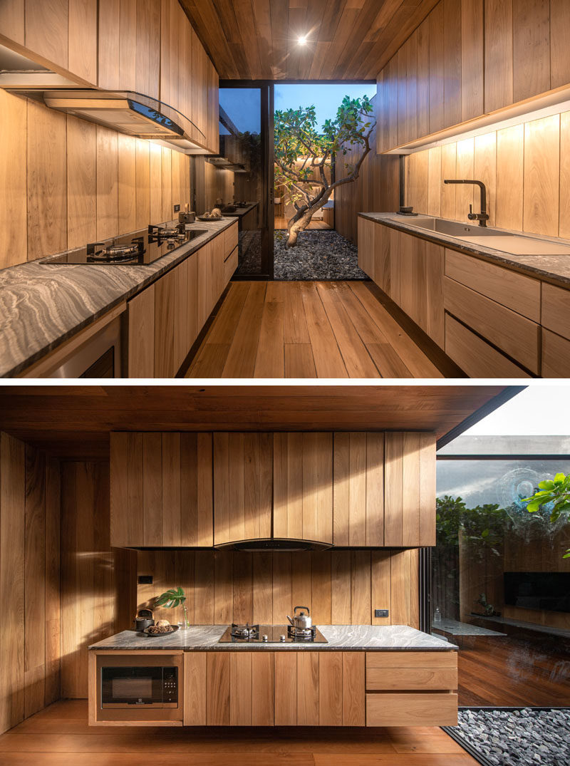 Kitchen Ideas - This modern kitchen has floating wood cabinets and access to a small courtyard with a tree. #ModernWoodKitchen #KitchenIdeas #WoodCabinets