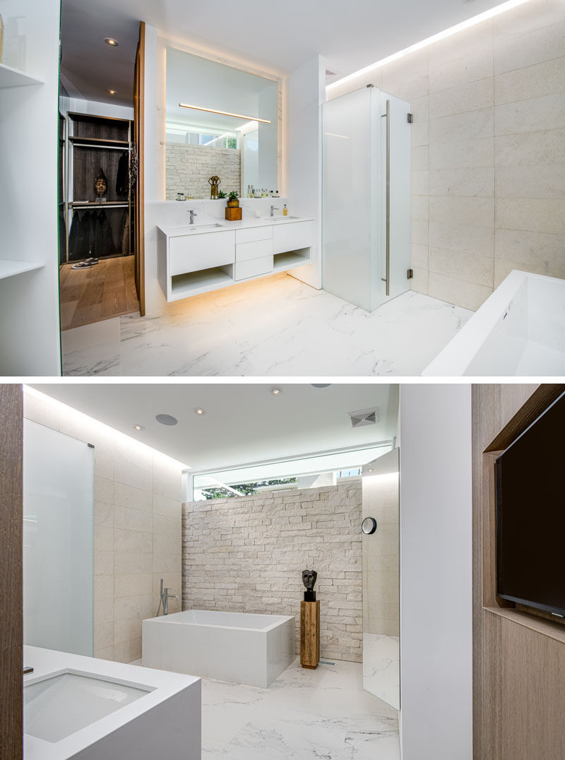 Bathroom Ideas - In this modern master bathroom, there's a floating vanity and mirror that both feature hidden lighting. Limestone walls in two styles, ledge and honed, are showcased and help to keep the bathroom bright. #BathroomIdeas #MasterBathroom #ModernBathroom