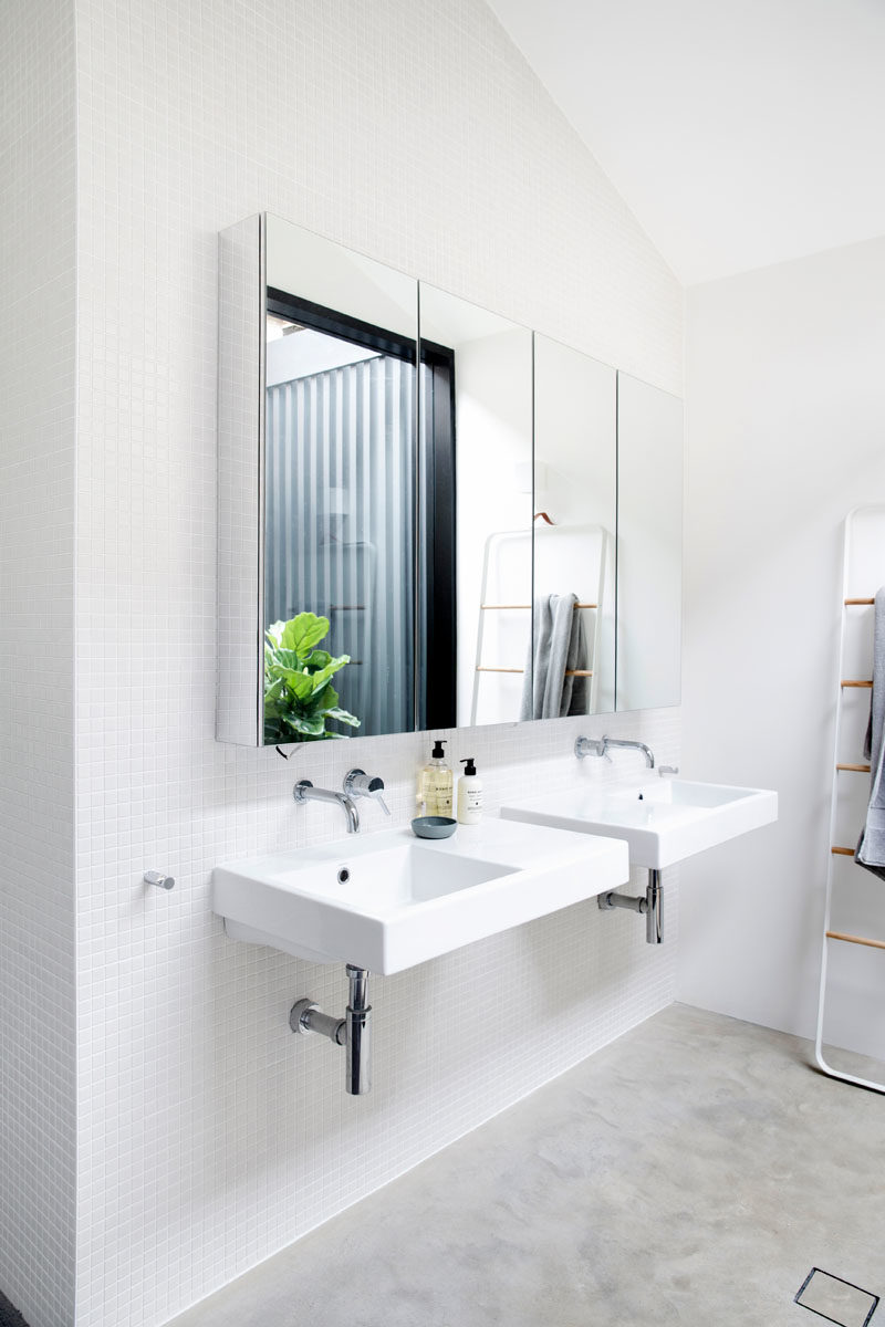 Bathroom Ideas - In this bathroom, dual sinks have been mounted below a mirror that reflects a small internal courtyard. #BathroomIdeas #ModernBathroom