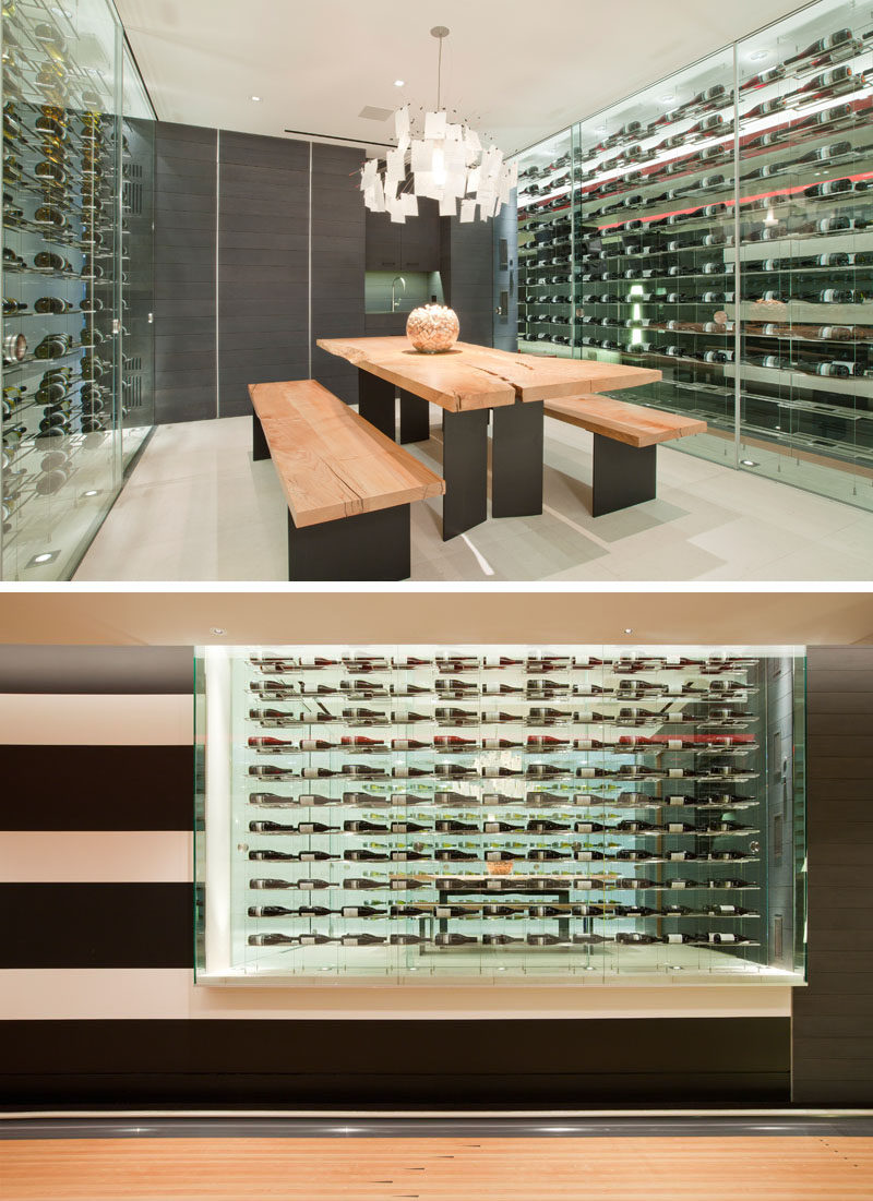 Wine Storage Ideas - This modern house has a custom-designed wine room that's furnished with a large wood and steel table and benches, while glass walls provide storage for the wine collection. #WineStorage #WineRoom