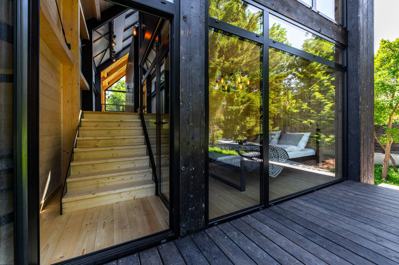 This modern resort house has black wood siding, and black framed windows. #BlackSiding #BlackWindowFrames