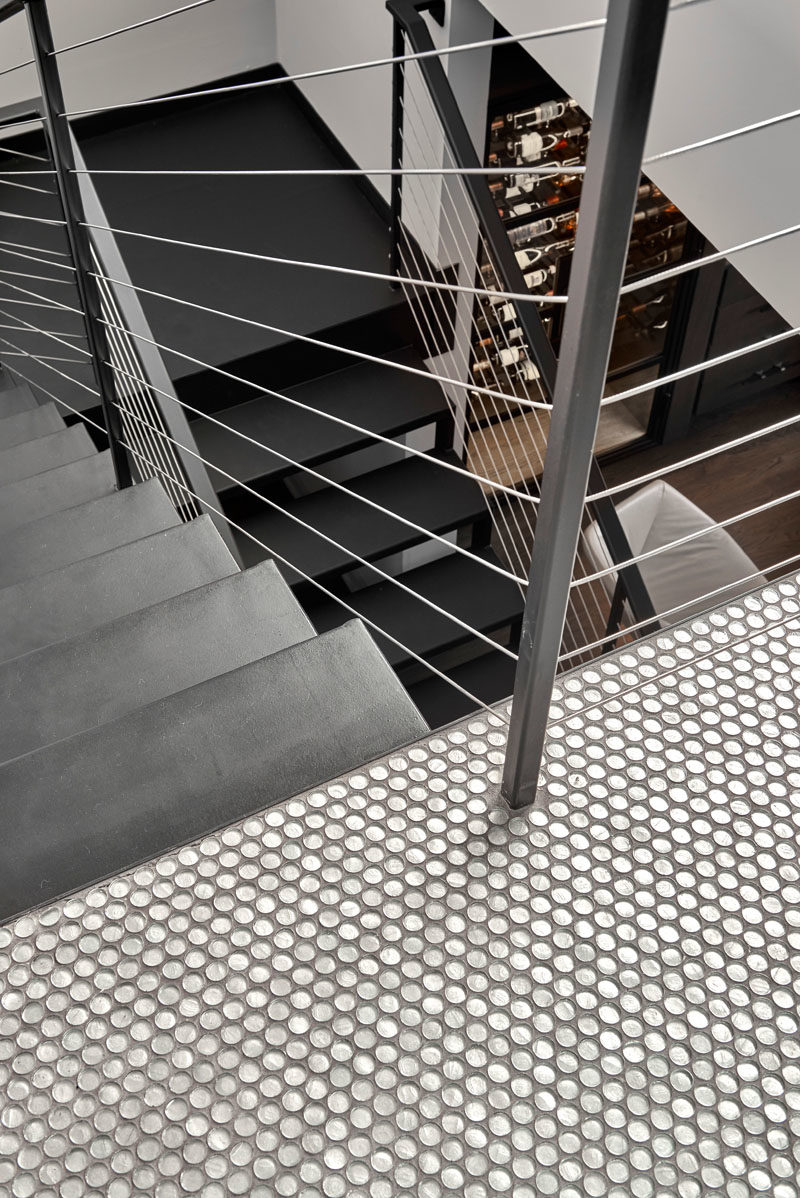 Stair Ideas - This modern blackened steel staircase leads up to the rooftop, while penny tiles add a fun touch at the top of the stairs. #StairIdeas #IndustrialStairs #ModernIndustrial #PennyTiles