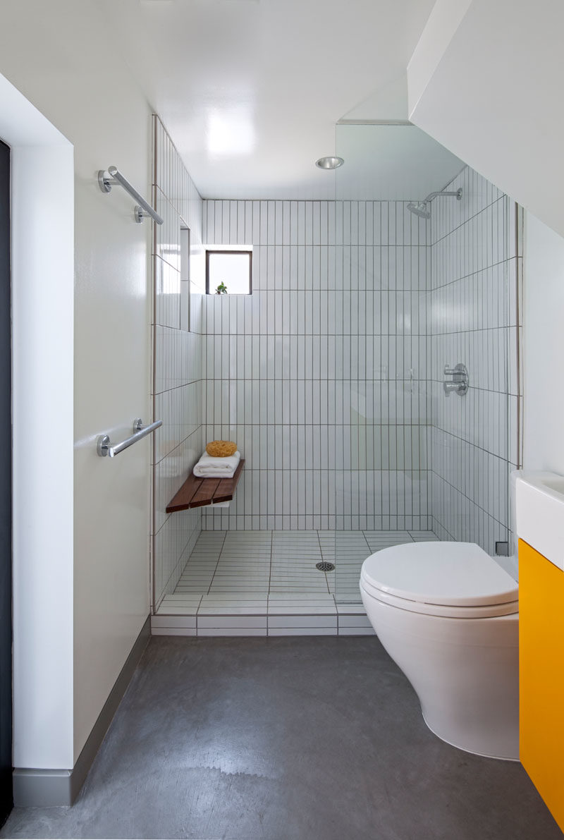 Bathroom Ideas - In this modern bathroom, a walk-in shower has vertically laid tiles, helping to create a sense of height in the small space. #BathroomIdeas #ModernBathroom #BathroomDesign
