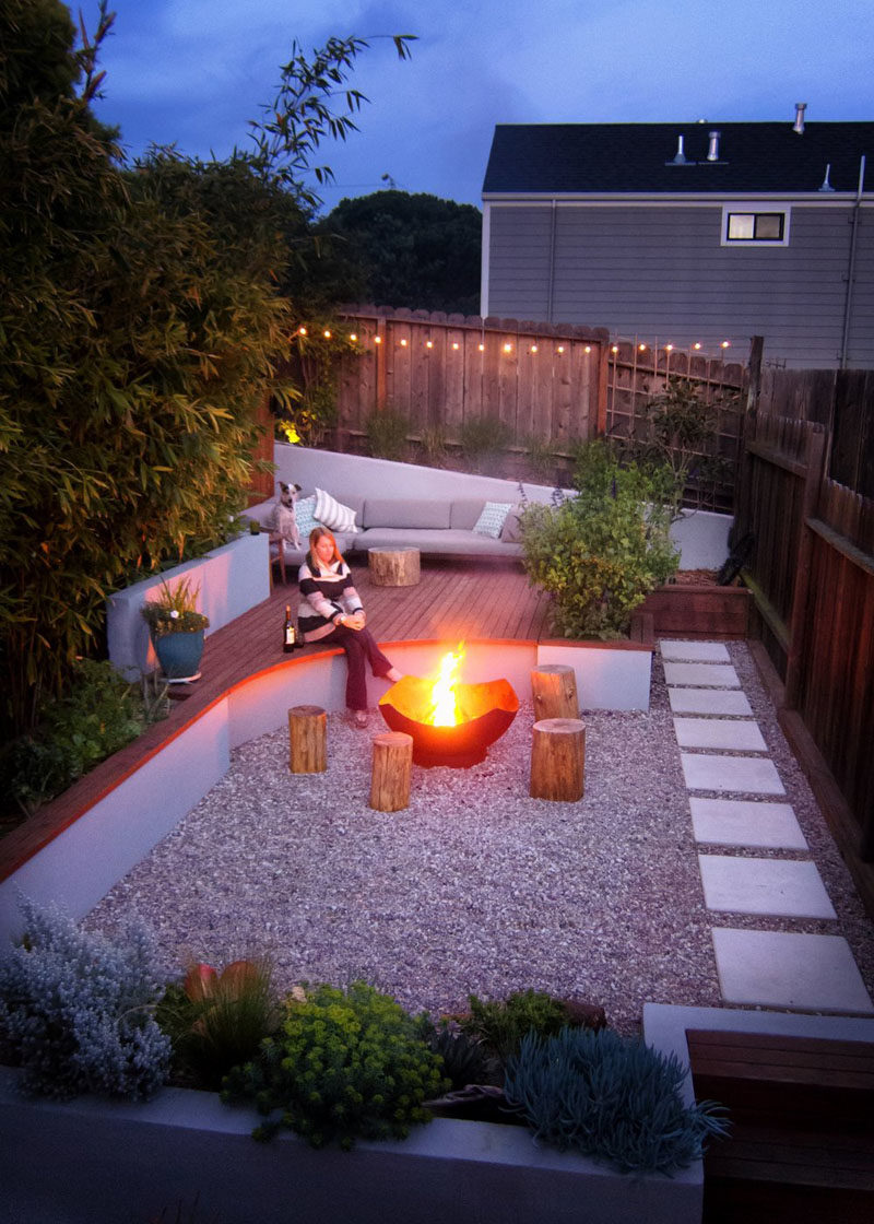 Landscaping Ideas - This modern landscaped backyard has a raised outdoor lounge deck, a wood burning firepit, succulents, bamboo, and a vegetable garden. #LandscapingIdeas #GardenIdeas #PlantIdeas #ModernYard #ModernBackyard #TieredYard