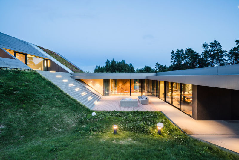 Architecture Ideas - This modern has been built into the hillside, integrating with the surrounding landscape, and creating a closeness to nature. #ArchitectureIdeas #GreenRoof #ModernHouse #ModernArchitecture #GlassWalls