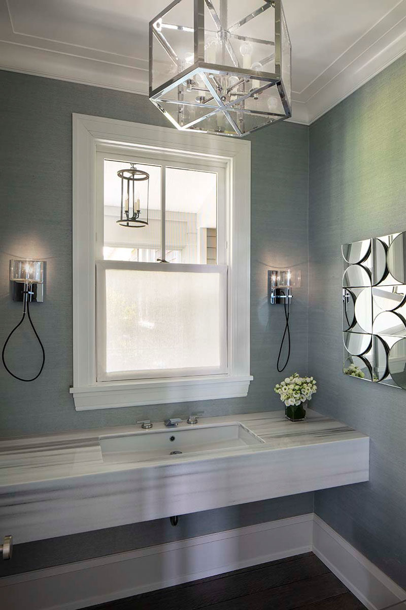 Bathroom Ideas - In this contemporary bathroom, textured grey wallpaper covers the walls, while chrome accents have been added in the form of lighting and wall art. #BathroomIdeas #BathroomDesign #GreyBathroom