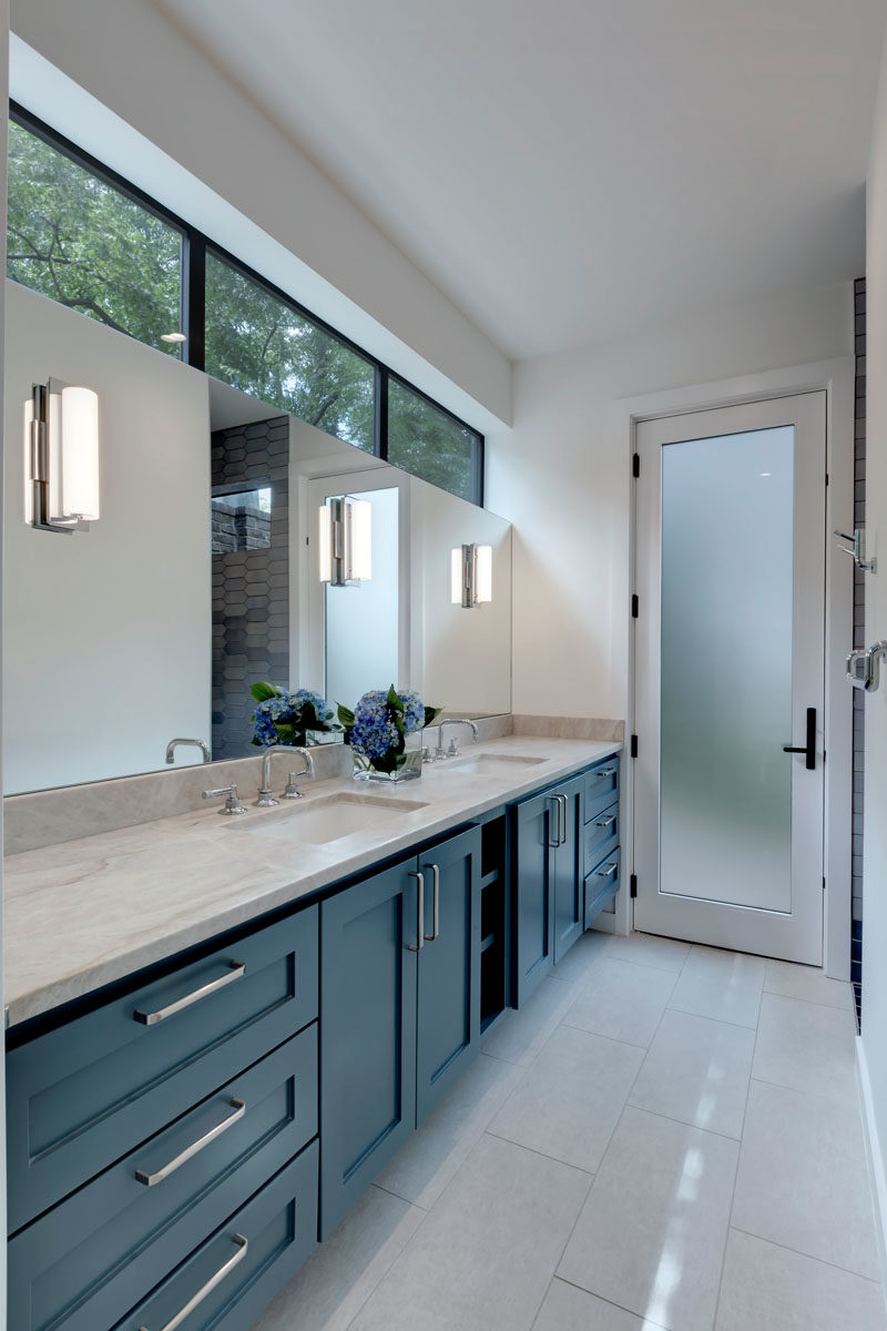 Bathroom Ideas - In this modern bathroom, clerestory windows and a frosted glass door add natural light to space, while a large vanity provides plenty of storage space. #BathroomIdeas #BathroomDesign #Modernbathroom