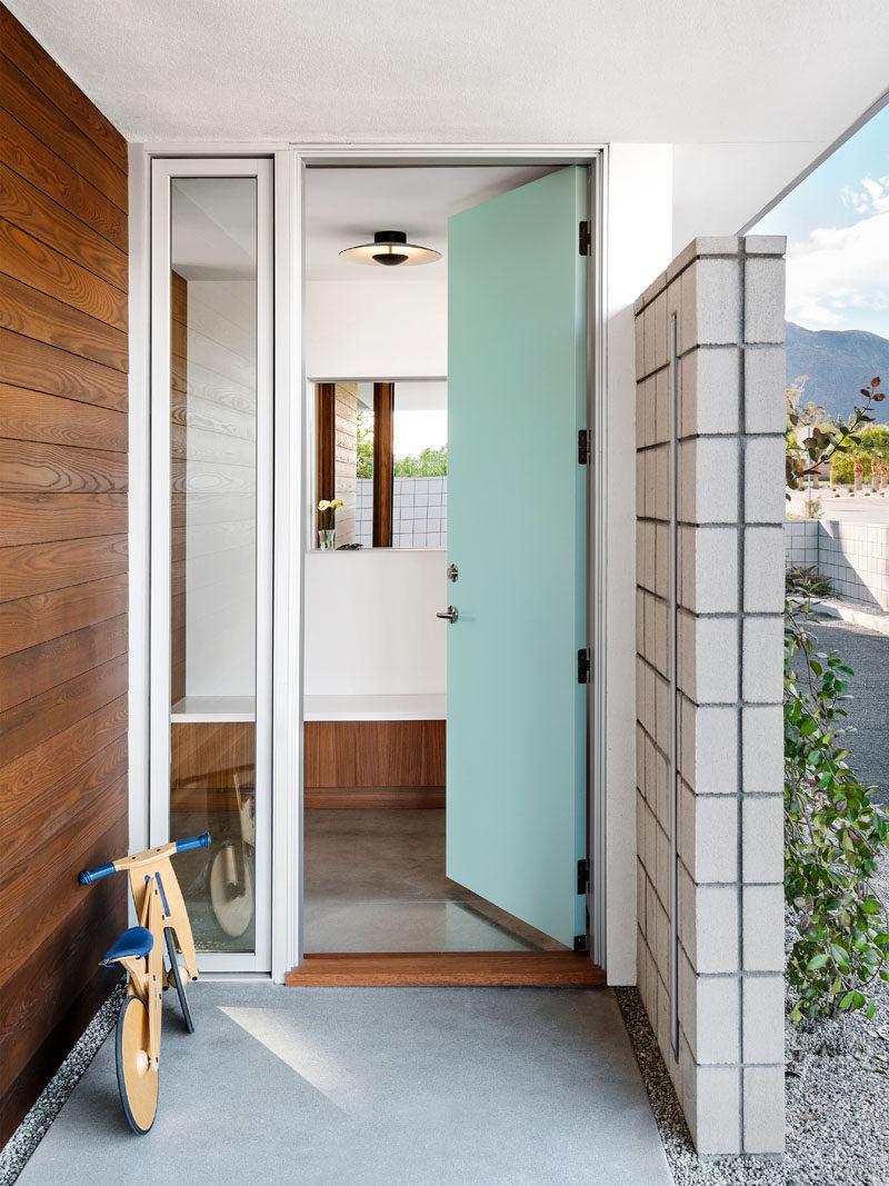 Front Door Ideas - A light blue front door welcomes visitors to this mid-century modern inspired house, that features polished concrete floors throughout. #BlueFrontDoor #FrontDoorIdeas #MidCenturyModern