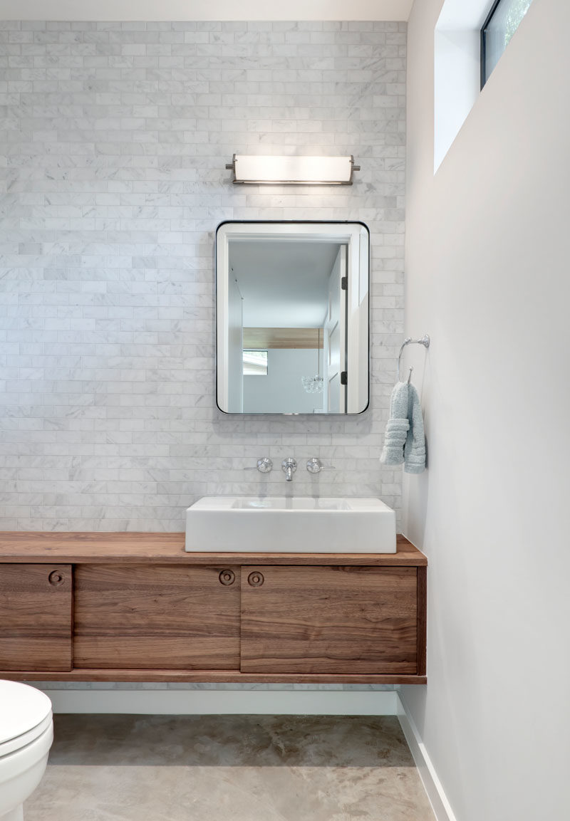 Bathroom Ideas - In this modern bathroom, light grey tiles cover the wall, and a simple floating wood vanity adds a natural element. #BathroomIdeas #ModernBathroom #BathroomDesign