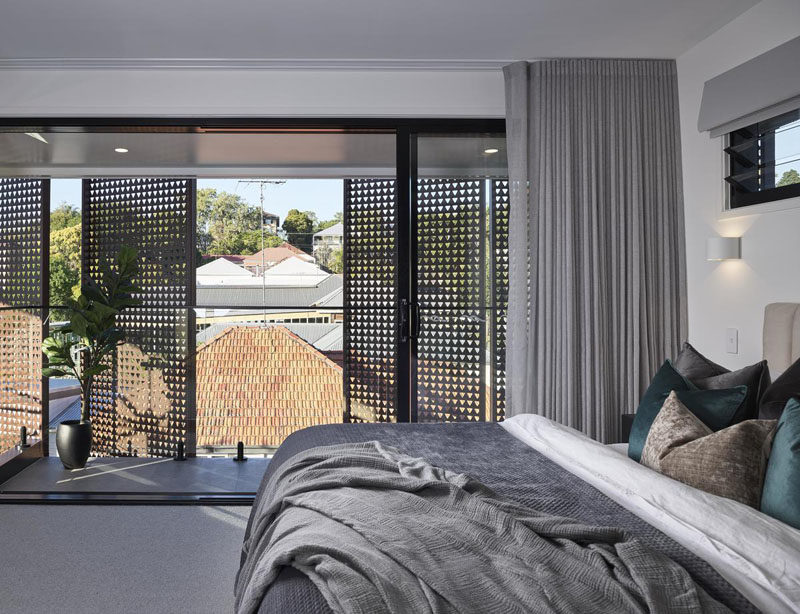 In this modern bedroom, a glass door opens to a small private balcony, while the metal screens allow for some privacy. #BedroomDesign #BedroomIdeas #Balcony #MetalScreens