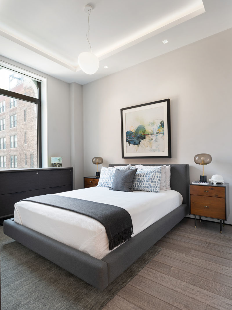 Flooring Ideas - Engineered greywashed rift and quartered white oak floors extend throughout this modern apartment, like in the bedroom. #Apartment #FlooringIdeas #WoodFlooring #InteriorDesign #BedroomIdeas