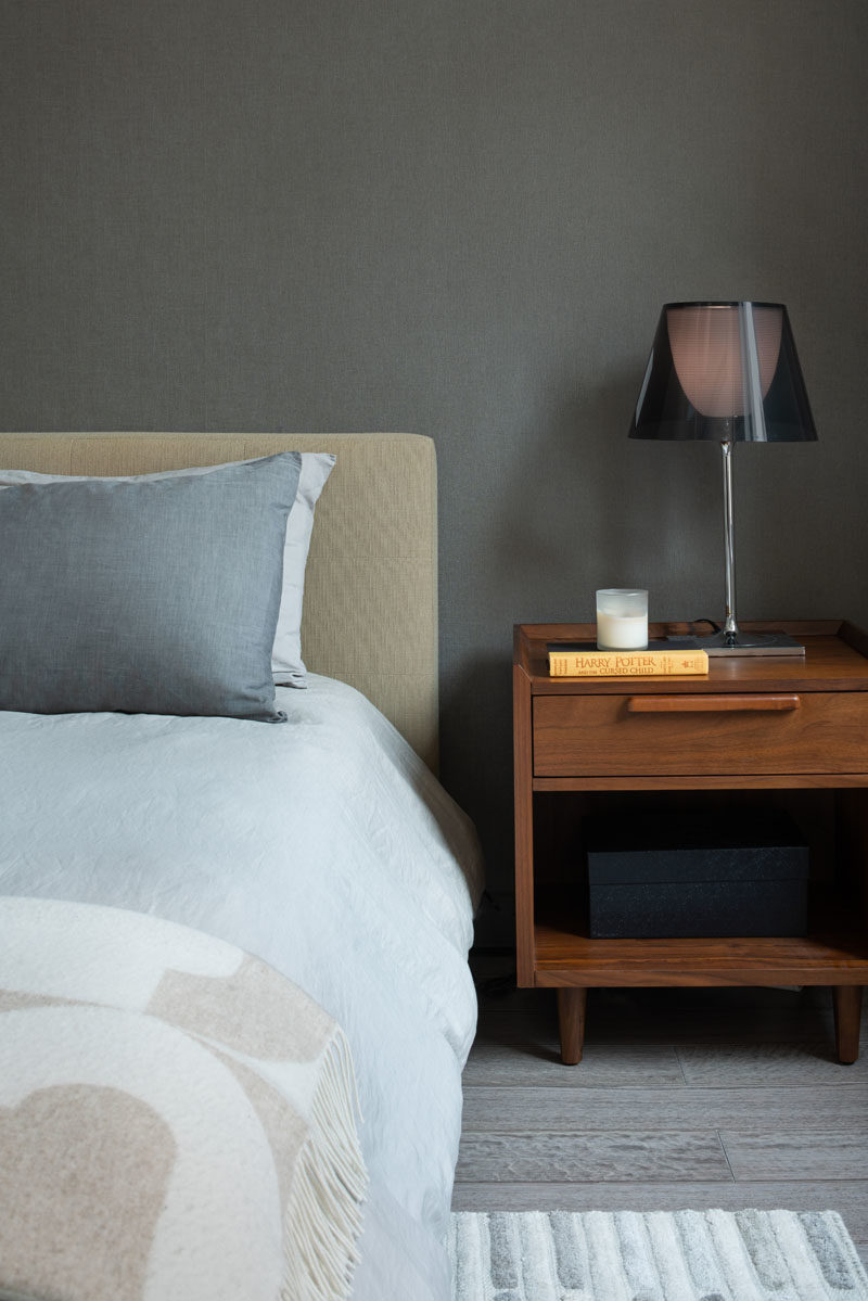 Bedroom Ideas - Subtle colors, wood furniture, and a dark wall create a calm atmosphere in this modern bedroom. #BedroomIdeas #ModernBedroom #WoodFlooring