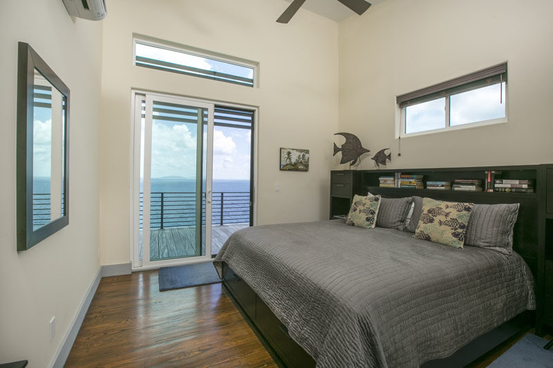 Bedroom Ideas - This modern bedroom has sliding glass doors that open to a porch that runs the length of the cottage. #Bedroom #ModernBedroom