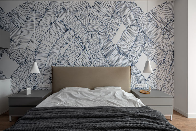 Bedroom Ideas - In this modern master bedroom, a leafy mural covers the wall behind the bed, while two minimalist white pendant lights hang from the ceiling. #BedroomIdeas #ModernBedroom #BedroomMural