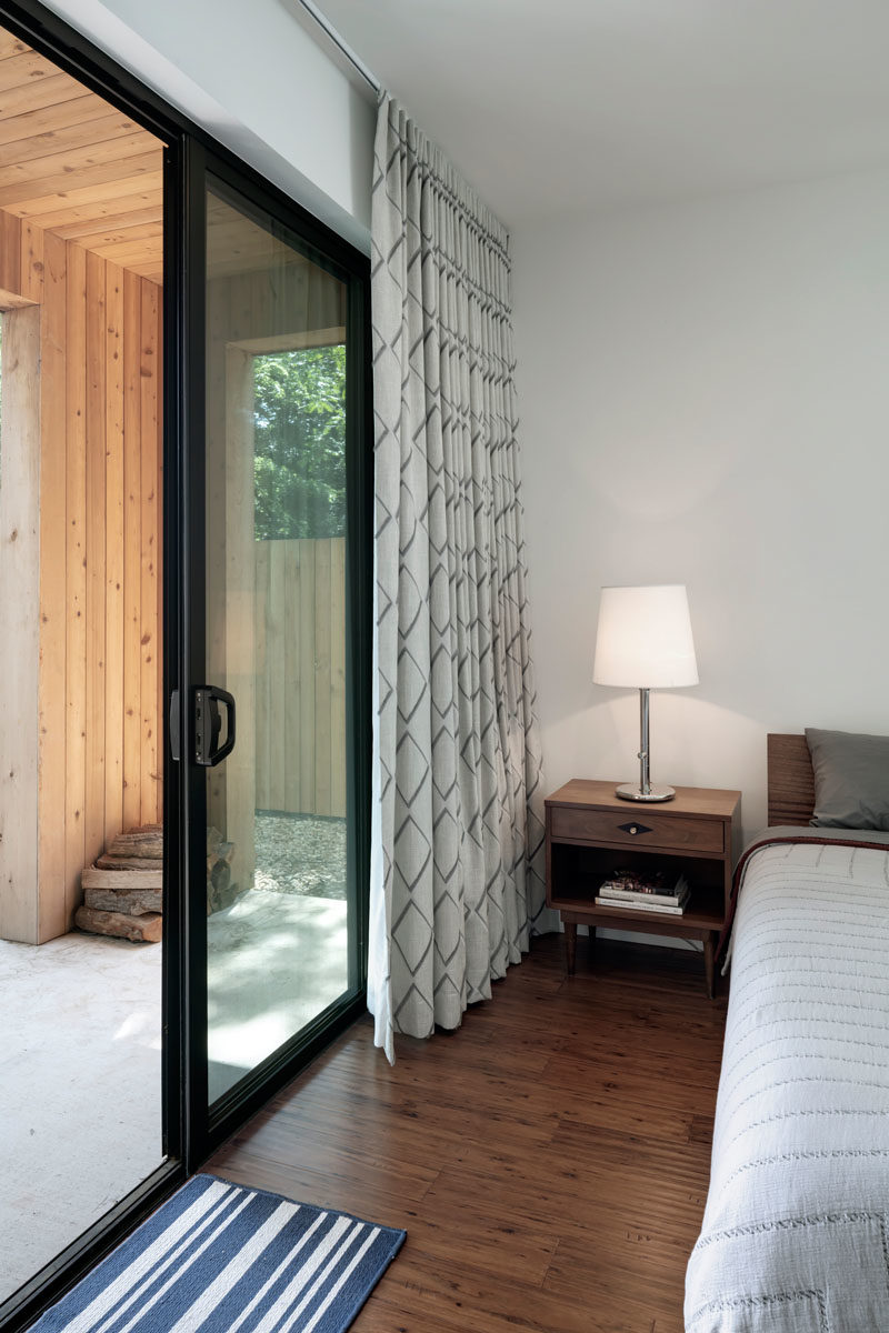 A small covered porch provides this bedroom with a private outdoor space, while inside, the furnishings have been kept minimal for a relaxed atmosphere. #Bedroom #SlidingDoor